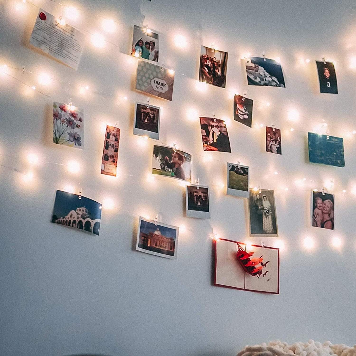 Wall of photos lit by the string lights